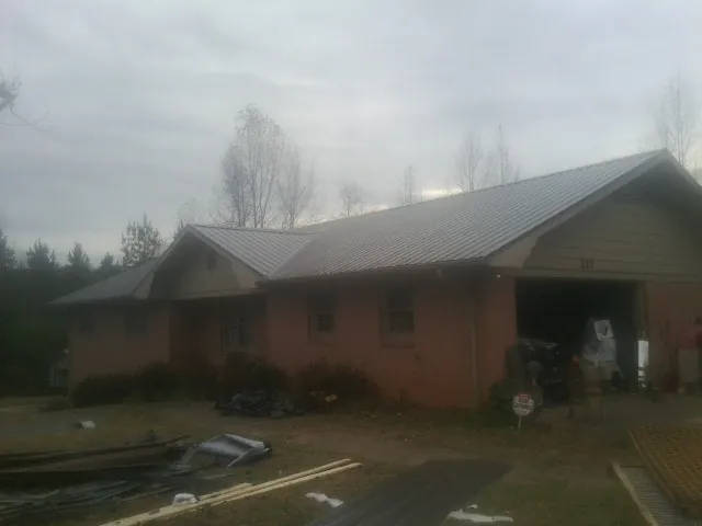 Gray metal roof on a stucco house with an attached garage in Newark
